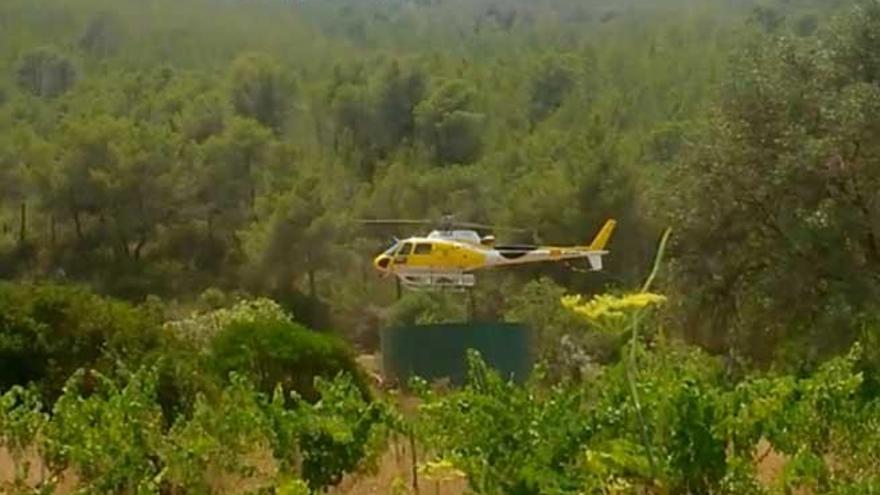 Un helicóptero carga agua en uno de los depósitos de la asociación.