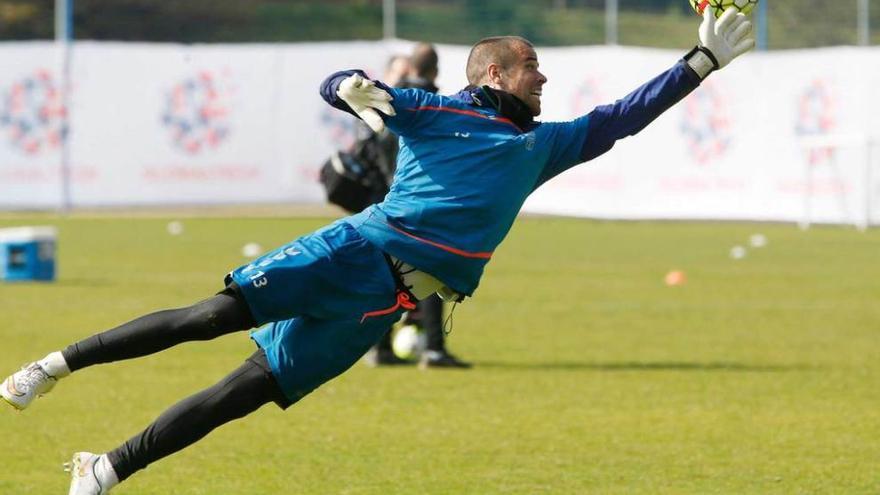 Miño se estira para intentar despejar un balón en un entrenamiento.