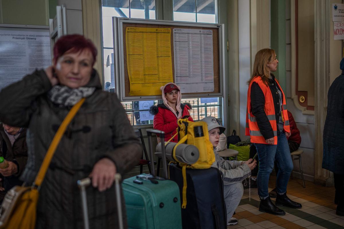 Evacuados ucranianos esperan en un pasillo de la estación de tren en Przemysl, cerca de la frontera polaco-ucraniana.