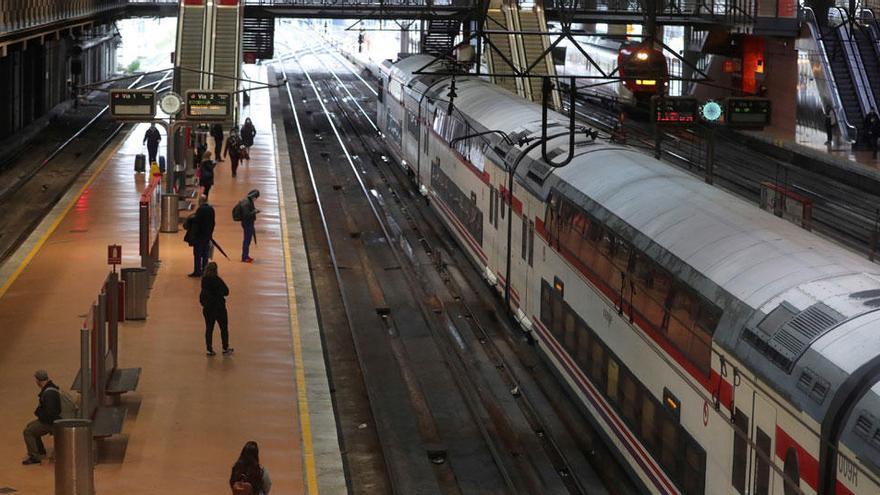 Varias personas guardan la distancia social en la estación de cercanías de Atocha-Renfe de Madrid.