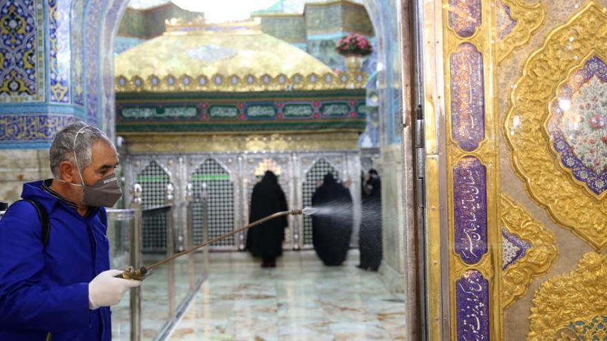 Un hombre desinfecta el Santuario de Fátima en la ciudad iraní de Qom.