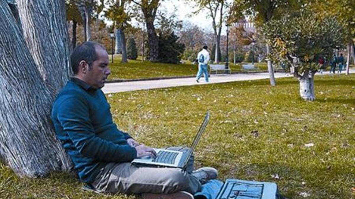 Un usuario utiliza el wifi público en el parque de la Ciutadella.