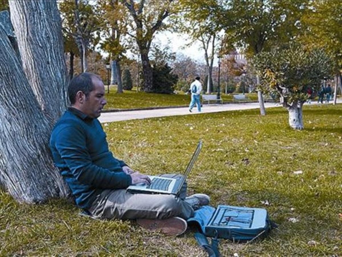 Un usuari utilitza el wifi públic al parc de la Ciutadella.