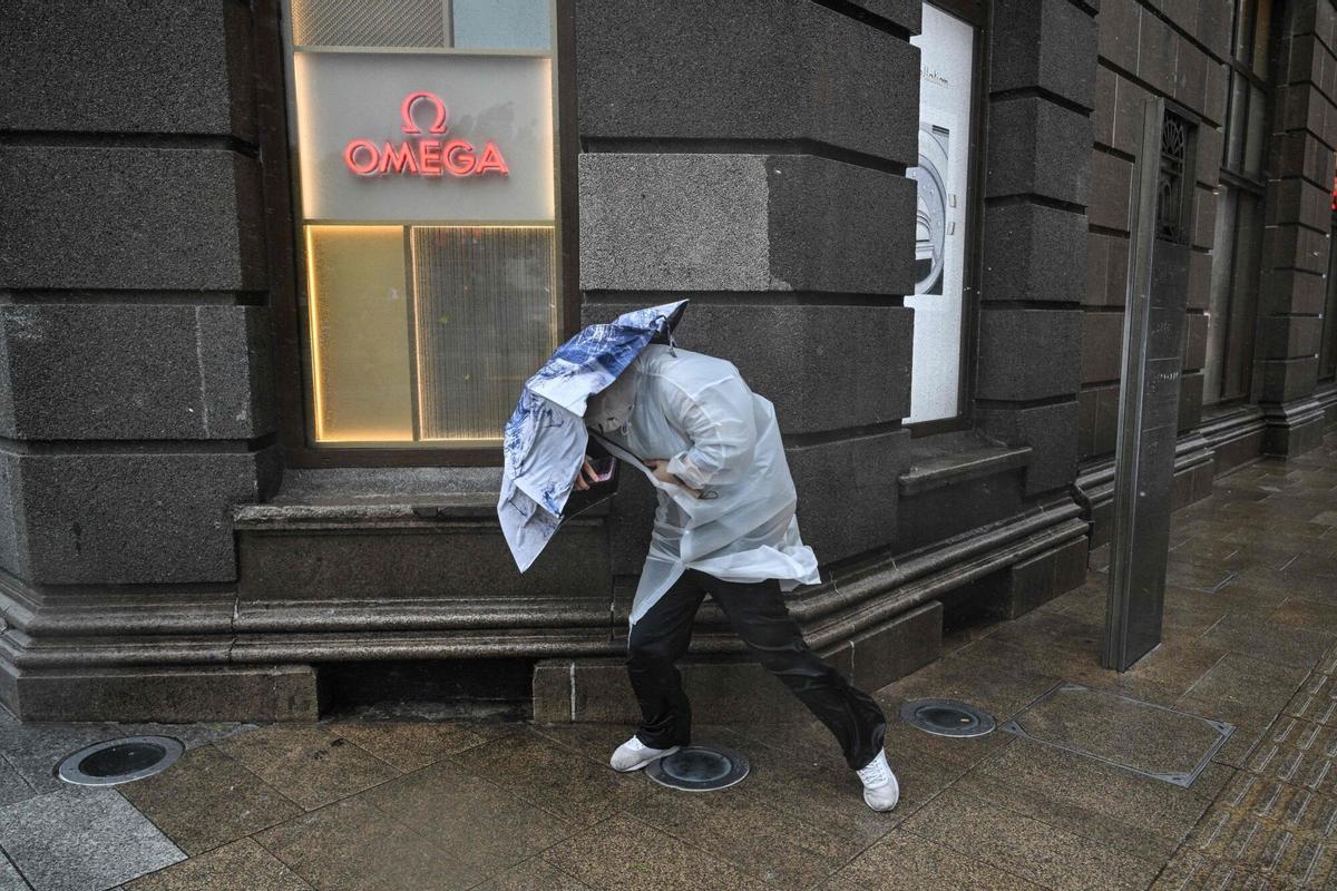 Una persona trata de protegerse de la lluvia en Shanghái, durante el paso del tifón Dolphin, este lunes.