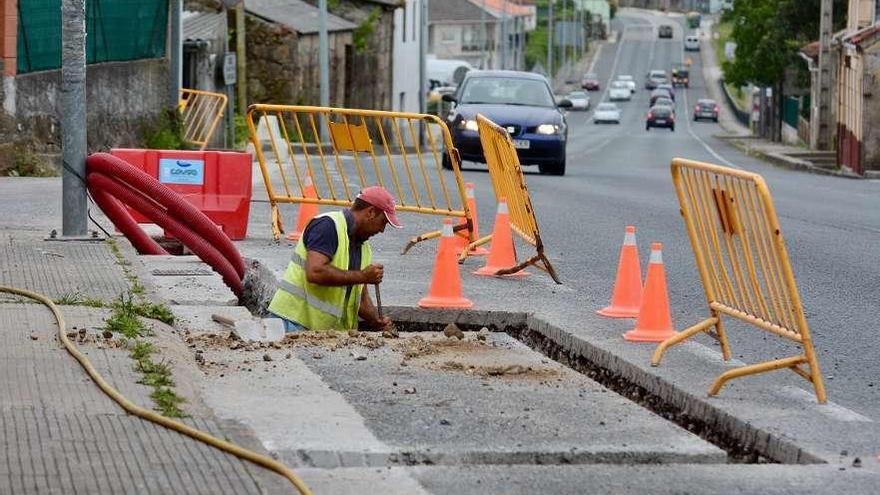 Trabajos para instalar los pasos de peatones con semáforos en la N-550 en Lérez. // Rafa Vázquez