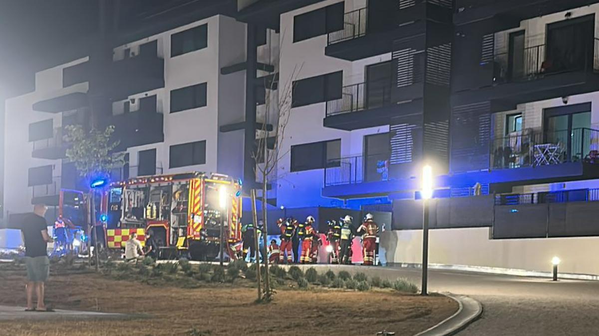 Vecinos del inmueble permanecen en la calle mientras los servicios de emergencia intervienen en el incendio registrado en Navalcarnero.
