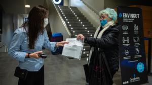 Una mujer muestra su pasaporte covid antes de entrar en el cine