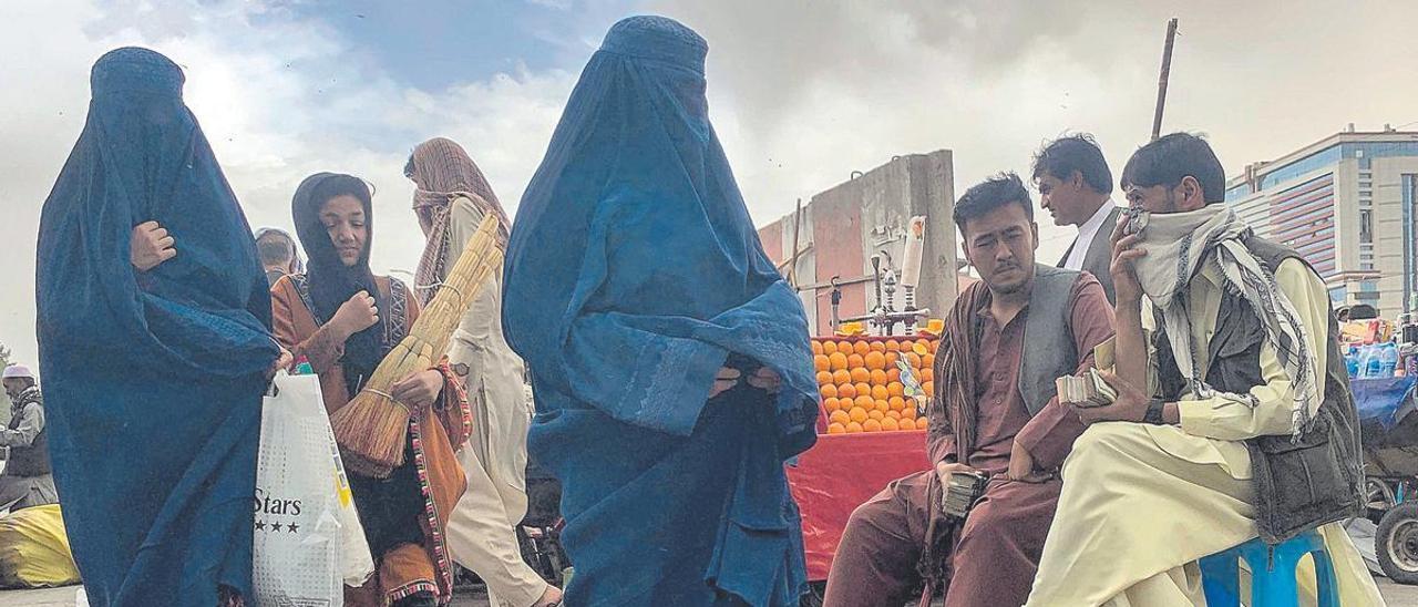 Mujeres afganas cubiertas con burka o hiyab enuna calle de Kabul.  (l) EFE / REUTERS / STRINGER