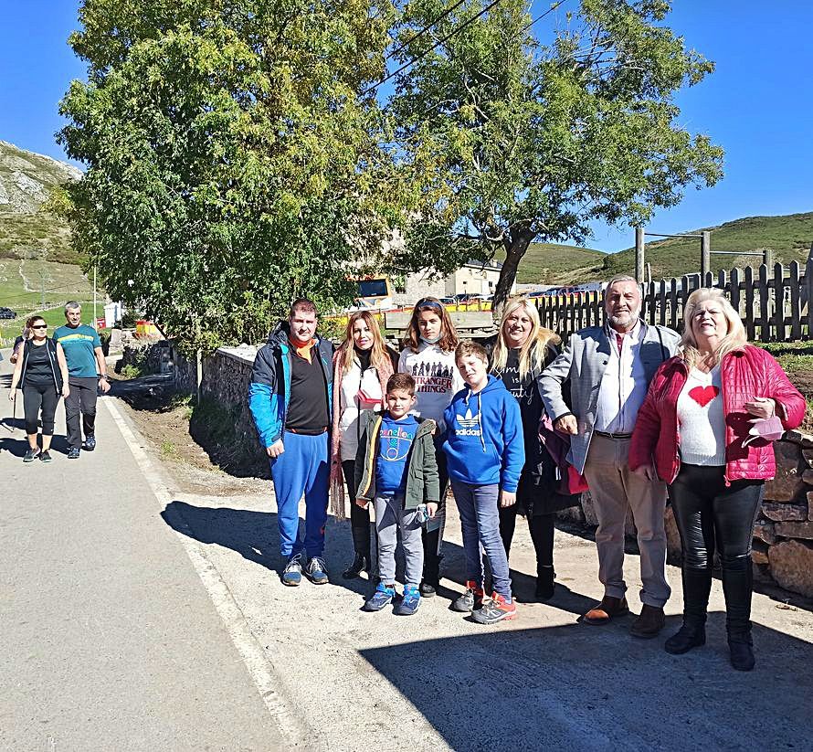 Jorge Martín, Lorena Bueno, Christian Martín, Sandra Núñez, Iván Núñez, Mónica Bueno, Ismael Bueno y Pilar Mozo posan en primer término; a la izquierda, dos visitantes caminan por la carretera. | S. Arias