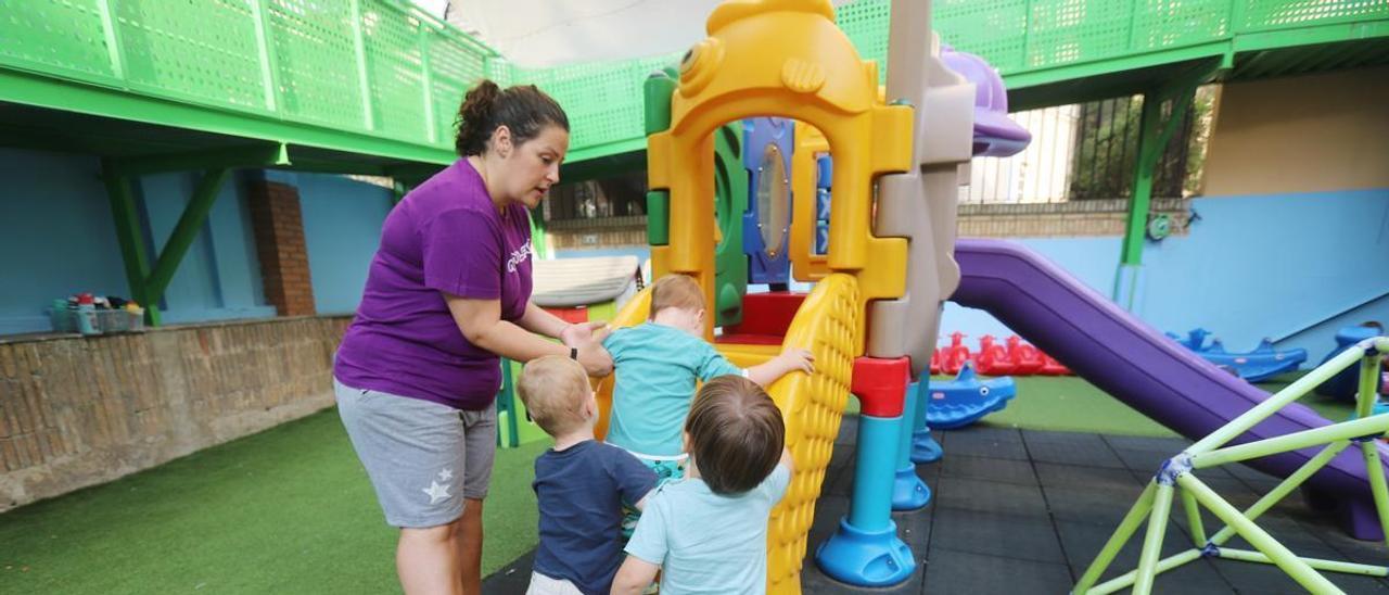 Una educadora juega con tres niños en Nanyland San Francisco, en la capital aragonesa.