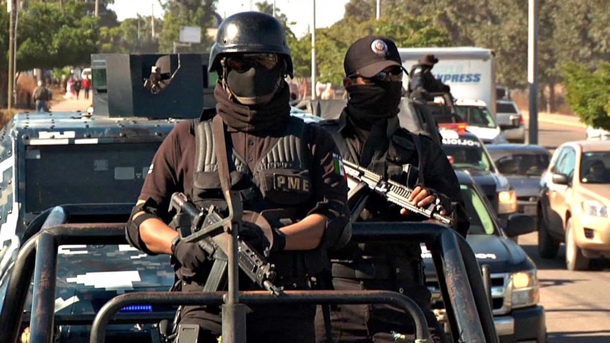 Dos agentes de la policía mexicana en un convoy de seguridad.