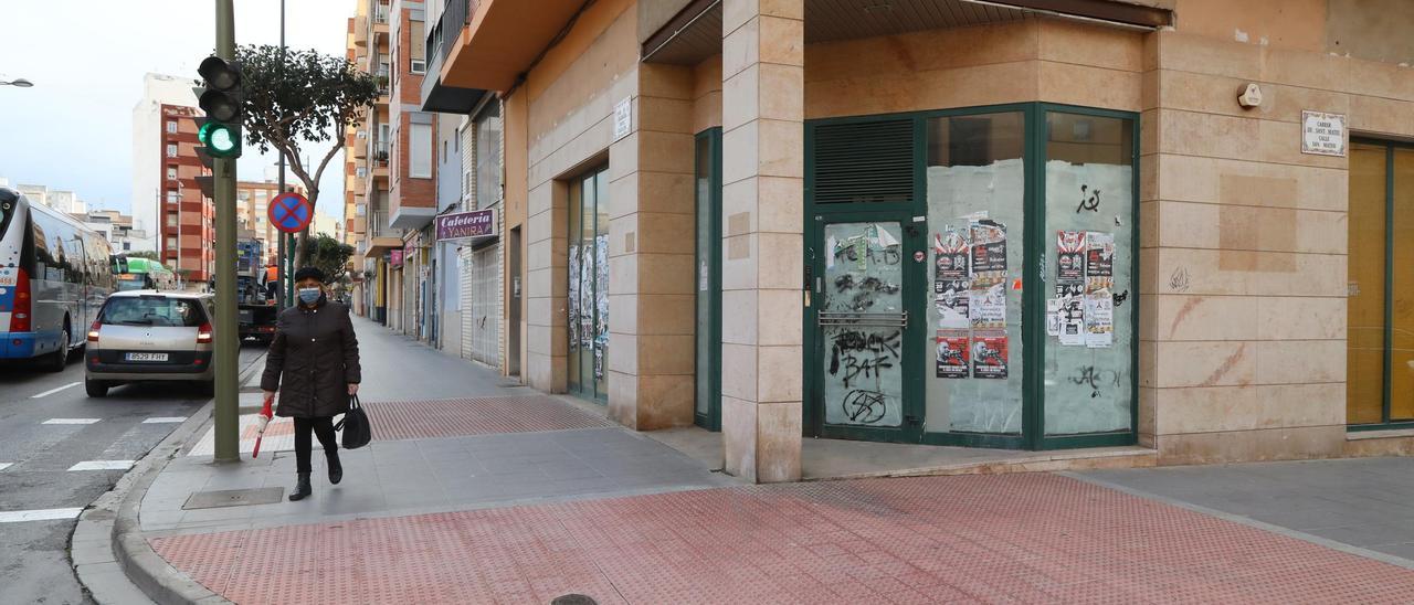 Una mujer pasa ante una de las muchas oficinas de entidades financieras que han cerrado sus puertas a lo largo de los últimos años en Castelló.