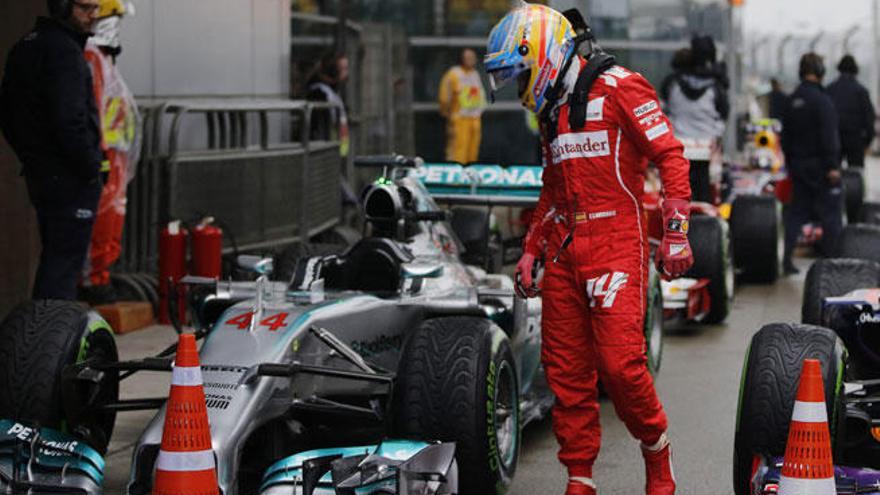 Alonso observa el Mercedes de Hamilton tras la calificación.