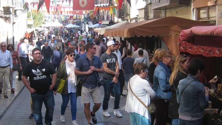 Toresanos y turistas recorren los puestos de venta del Mercado Medieval instalados en la Plaza Mayor y en la calle La Mayor.