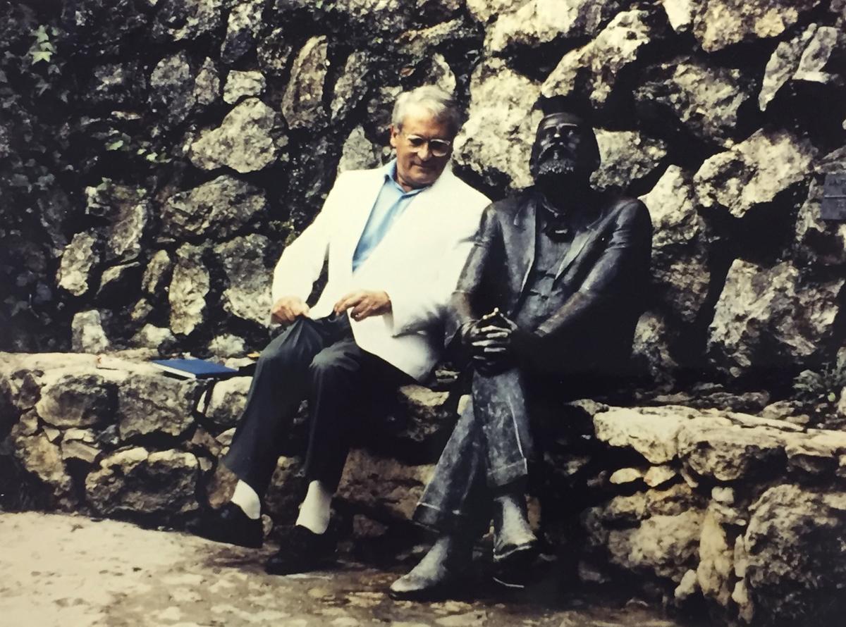 Bohigas, sentado junto a la estatua dedicada a Gaudí en Comillas, arquitecto al que admiraba tanto como detestaba que su obra magna, la Sagrada Família, fuera construida de forma póstuma.