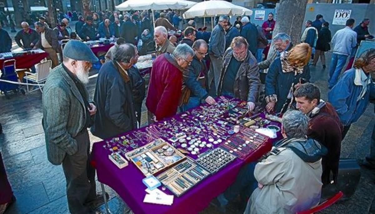 Un grup de col·leccionistes observen el material d’una de les parades de la fira de la plaça Reial, ahir. Un grup de col·leccionistes observen el material d’una de les parades de la fira de la plaça Reial, ahir.