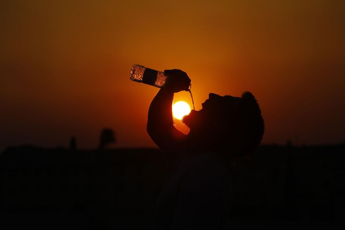  Un hombre bebe agua en el puente romano de Córdoba el atardecer en una jornada donde continua la ola de calor con temperaturas que alcanzan los 43 grados. 