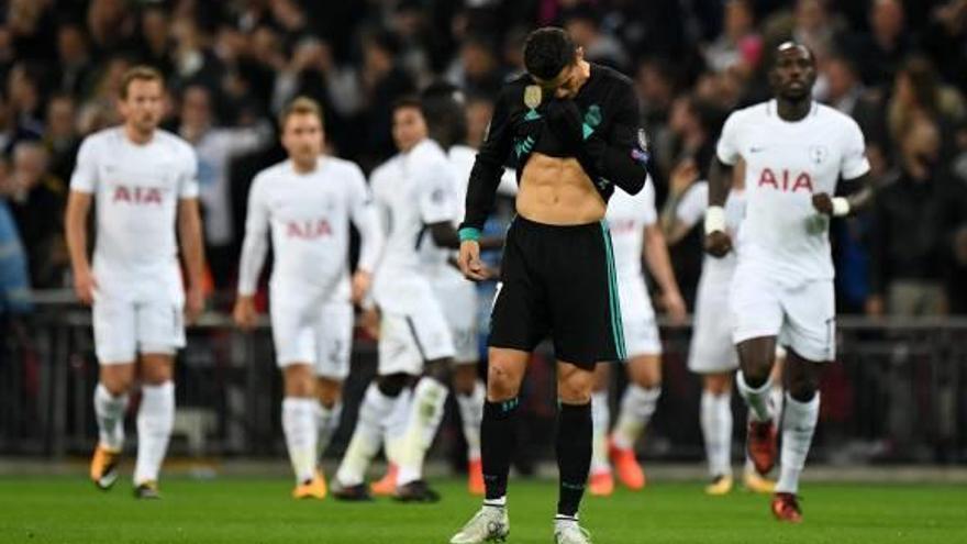 Cristiano Ronaldo, capcot en primer pla, amb els jugadors del Tottenham celebrant un gol.
