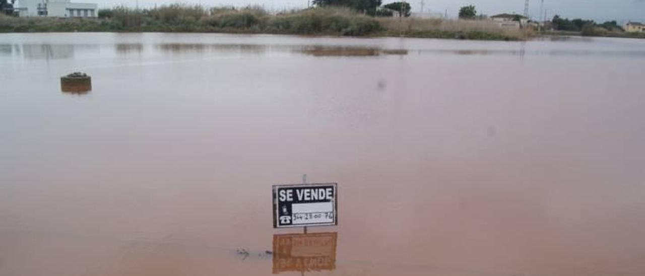 Cartel de «Se Vende» en una de las parcelas del Cuadro de Santiago durante las pasadas lluvias del mes de marzo.