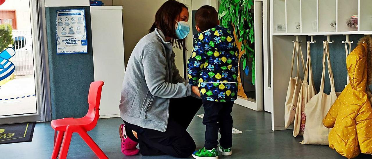 Una profesora ayuda a un niño en la escuela infantil de Rons.