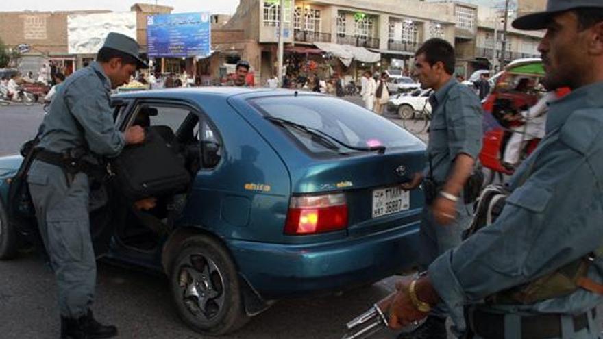 Varios policías afganos inspeccionan un vehículo en uno de los puestos de control de Herat, en Afganistán. i EFE