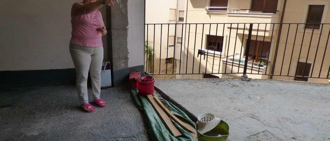 María del Carmen Menéndez, en la entrada a los garajes del piso -2, donde mantienen una pequeña barrera para frenar la entrada de agua, en Cangas del Narcea.