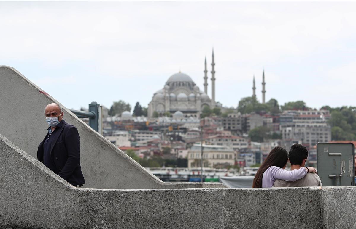 Una pareja sentada en una terraza frente a la Mezquita de Suleymaniye. 