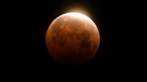 FILE - Light shines from a total lunar eclipse over Santa Monica Beach in Santa Monica, Calif., Wednesday, May 26, 2021. (AP Photo/Ringo H.W. Chiu, File). FILE PHOTO