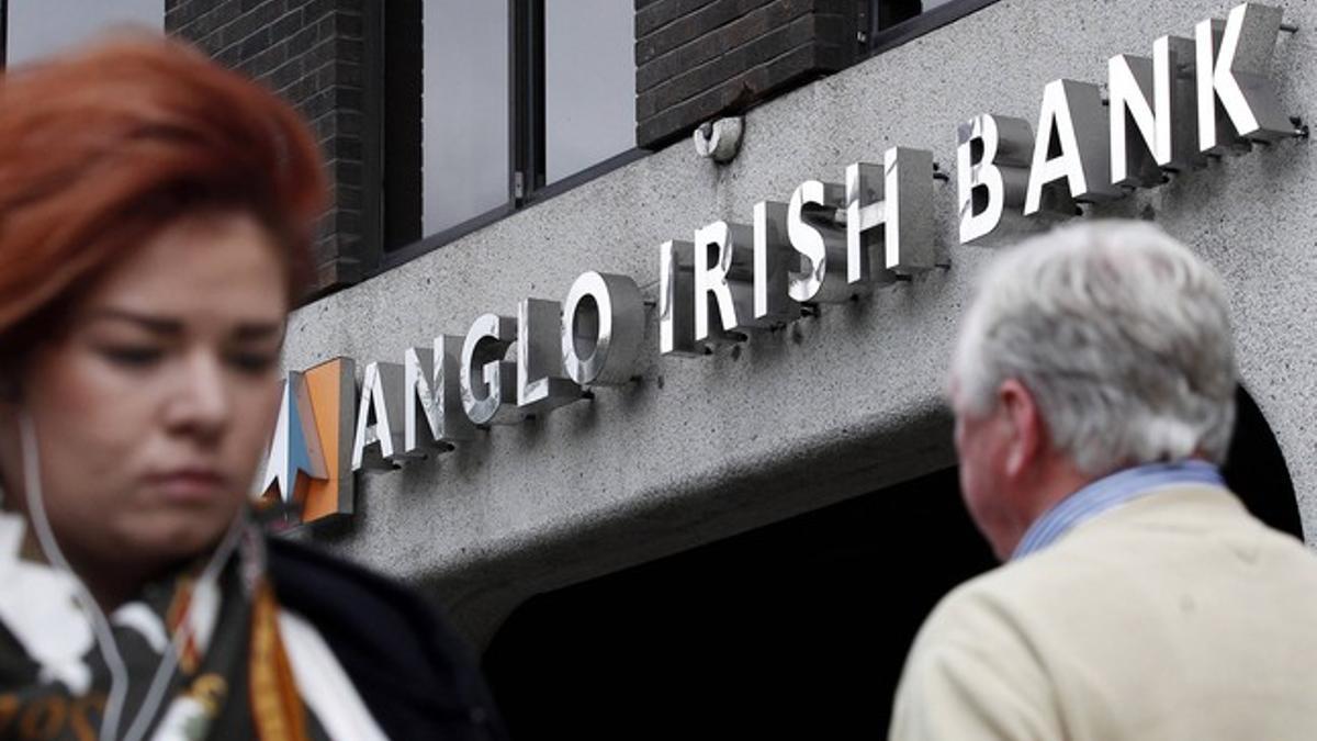 Dos viandantes pasan por delante de una agencia del Anglo Irish Bank, en Dublín, en septiembre del 2010.