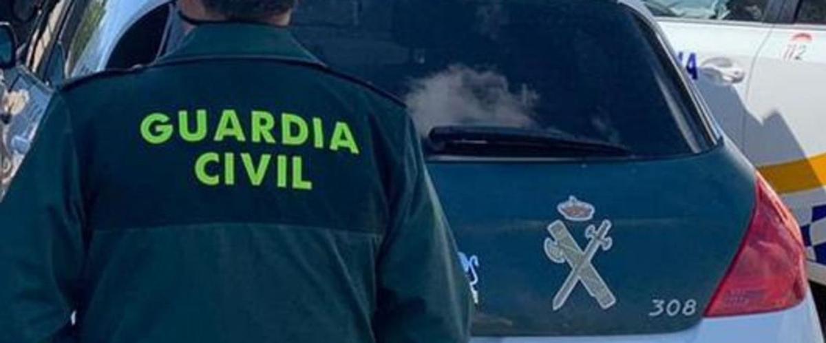 Un guardia civil, junto a un coche del instituto armado. |   // EUROPA PRESS