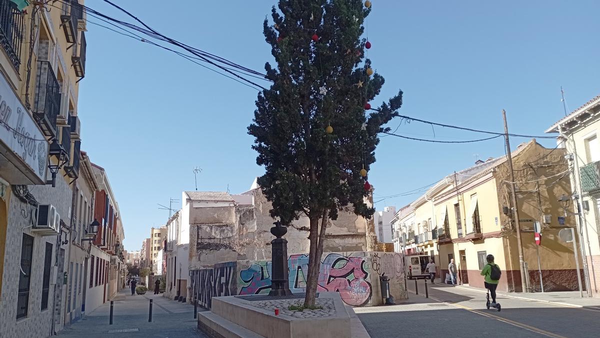 La fuente de la Olla de la plaza de Montes, con los adornos de Navidad en el ciprés vecino.