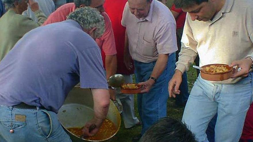 Asistentes a una de las comidas de la Faguía de Carnés, durante el reparto de los callos.