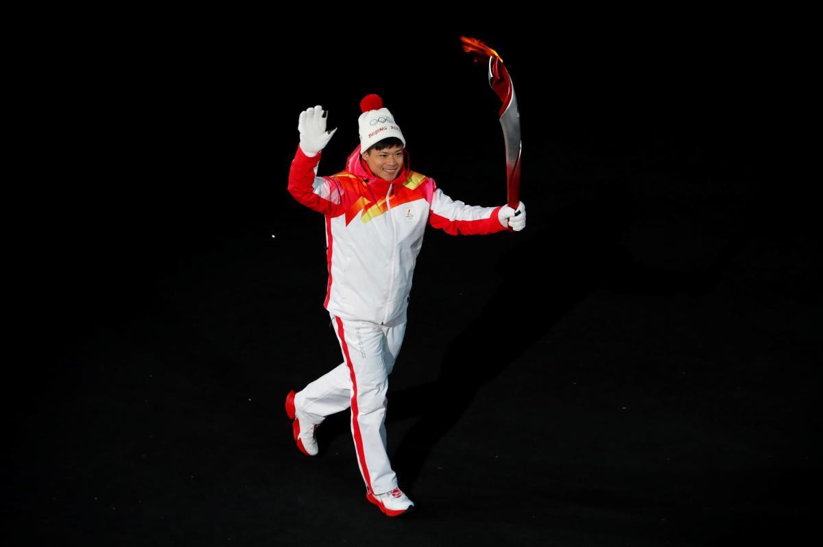  El atleta chino de pista y campo Su Bingtian porta la antorcha con la llama olímpica durante la Ceremonia de Apertura de los Juegos Olímpicos de Pekín 2022.