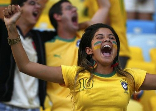 Fan of Brazil celebrates her team's victory over Chile as he waits the 2014 World Cup round of 16 game between Uruguay and Colombia at the Maracana stadium in Rio de Janeiro