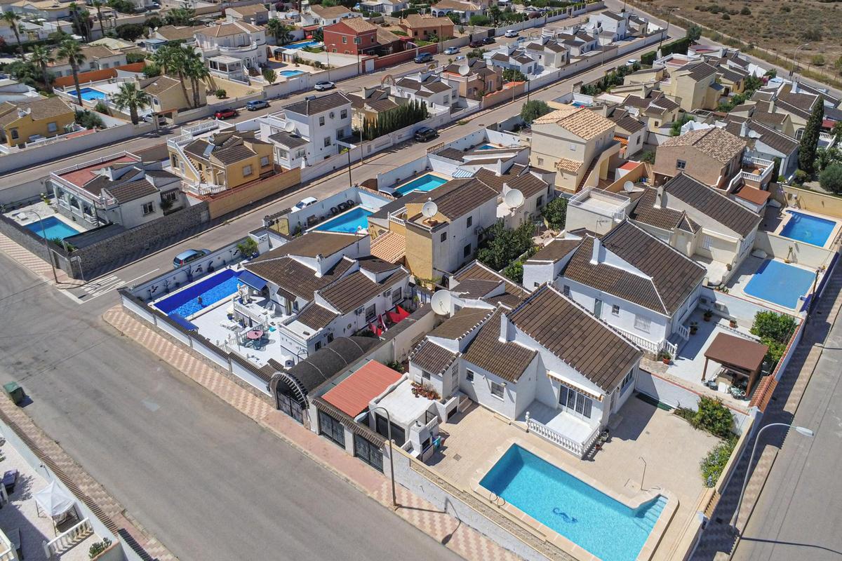 Piscinas adosadas unas a otras en una urbanización de viviendas unifamiliares de Torrevieja.