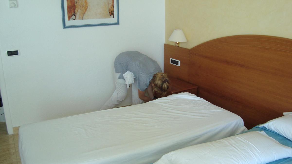 Una kelly hace una cama en un hotel de Ibiza.