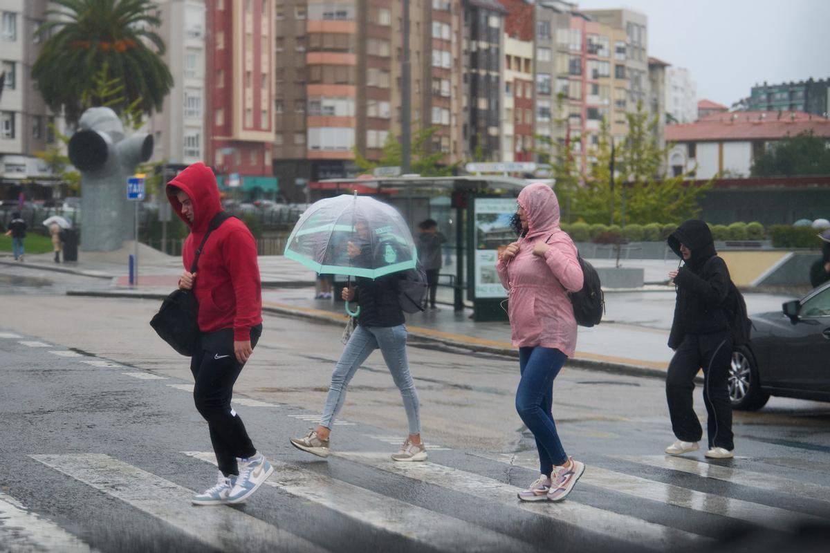 Varias personas se cubren de la lluvia y el viento con paraguas en una imagen de archivo.