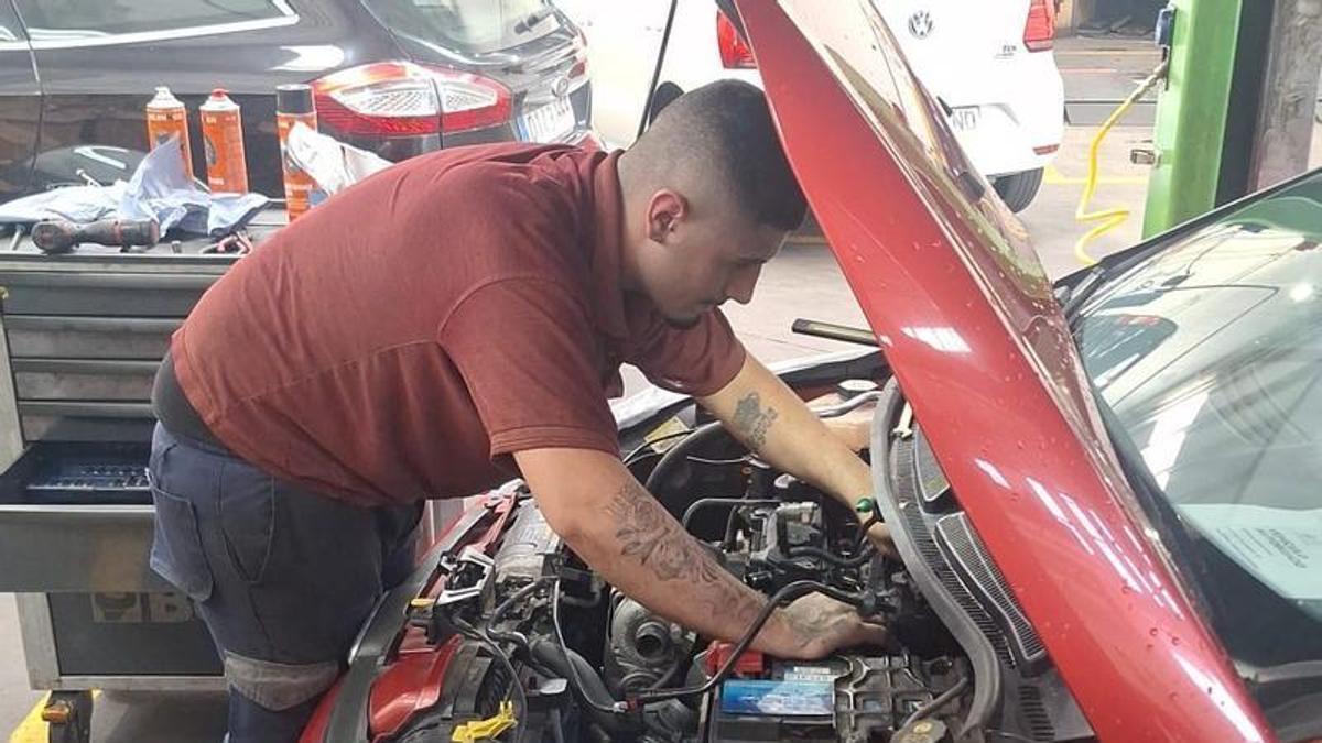 Un mecánico repara un coche en Ames Diésel, en Milladoiro