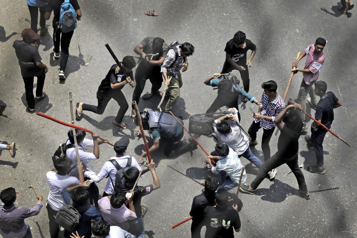 Varios estudiantes golpean a un policía durante una protesta en Dhaka, Bangladesh, el 18 de julio.