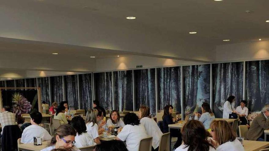 Clientes sentados en las mesas de una cafetería del HUCA. En el recuadro, un tique de un cliente descontento.