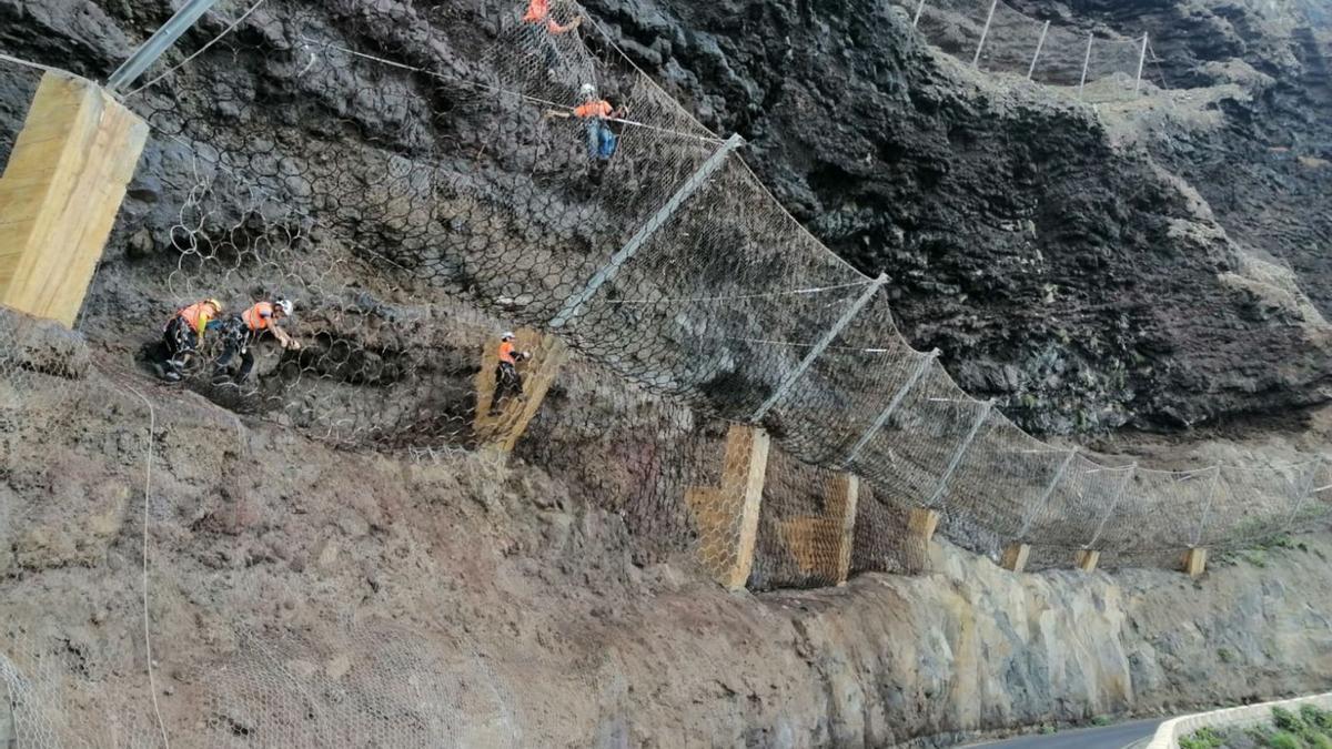 Los operarios de esta obra, especializados en trabajos verticales, pasan horas colgados de los acantilados del acceso a Punta de Teno. | | EL DÍA