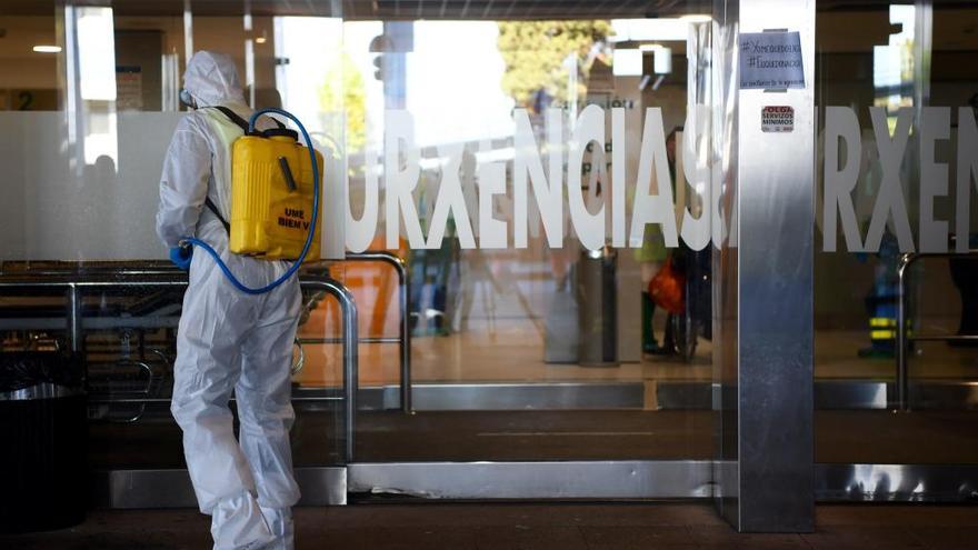 Un militar desinfecta la entrada de las Urgencias del hospital de A Coruña // Carlos Pardellas