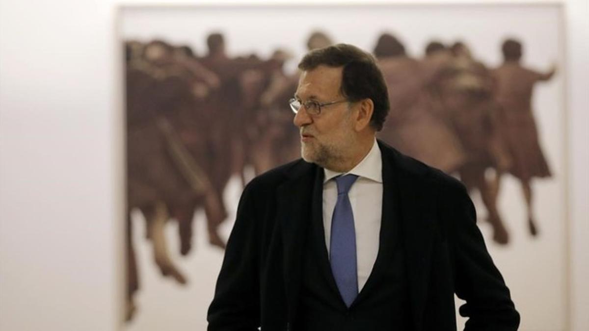 Mariano Rajoy, presidente del Gobierno en funciones junto al cuadro de Juan Genovés, presentado el jueves, después de recoger las credenciales de diputado hoy, en el Congreso de los Diputados.