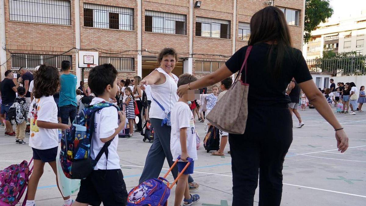 Una madre acompaña a sus hijos al colegio.