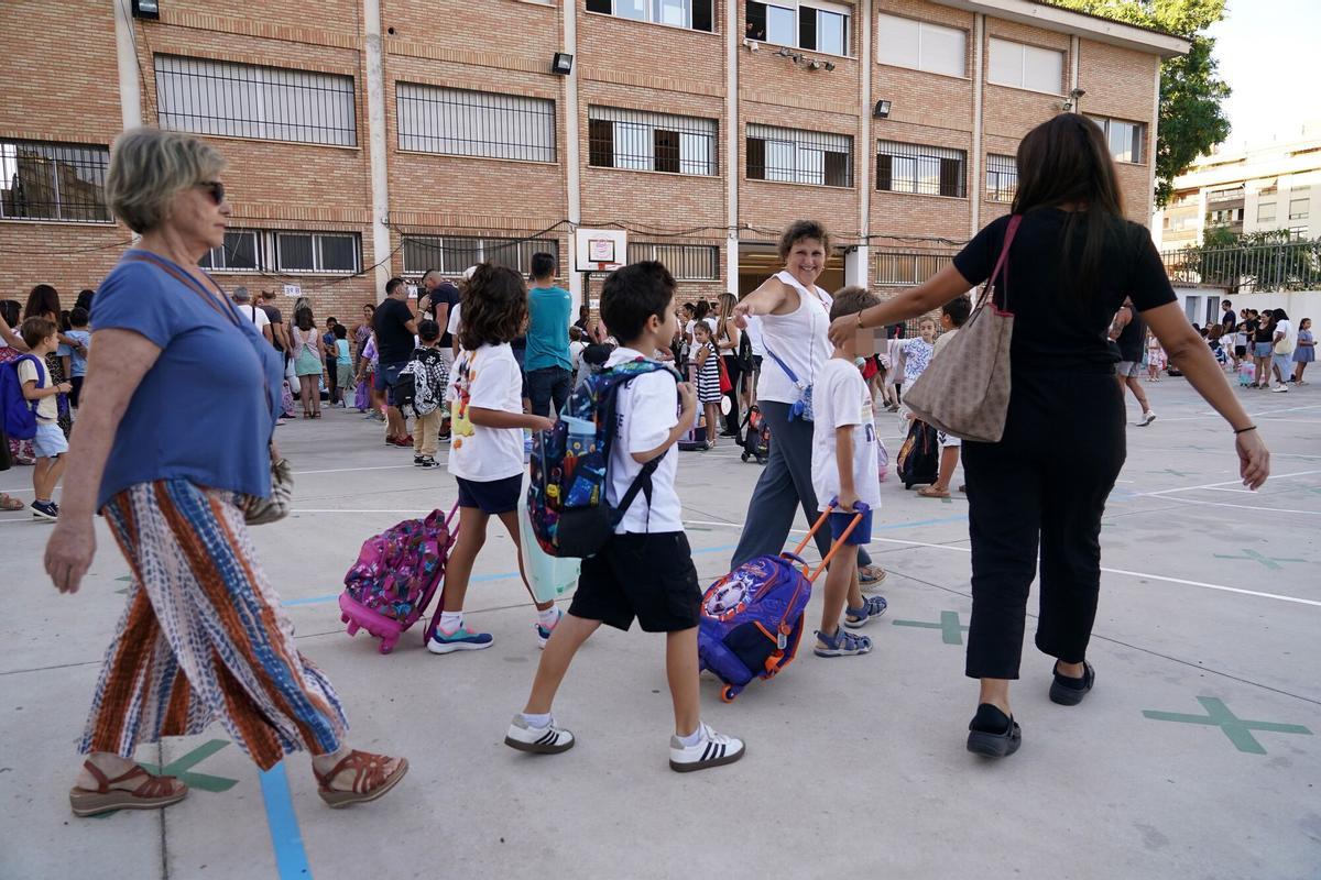 Una madre acompaña a sus hijos al colegio.