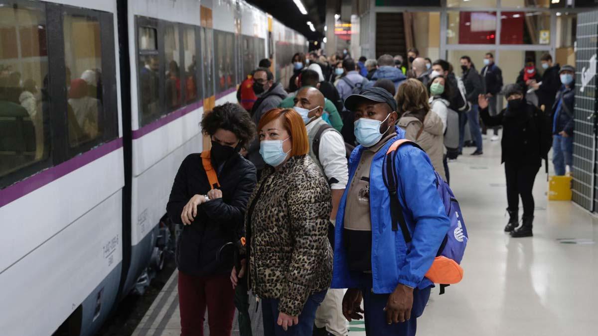 Pasajeros esperan para tomar el tren en la estación de Sants en la mañana en la que la R1 ha sido cortada por una avería eléctrica. El de la vía es el primer tren que iba a salir en dirección a Blanes y los usuarios tenían que seguir en autobús al llegar a Ocata