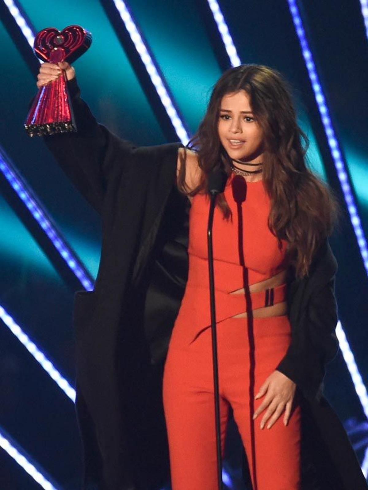 Selena Gomez muestra orgullosa su premio en la gala iHeartRadio Awards 2016.
