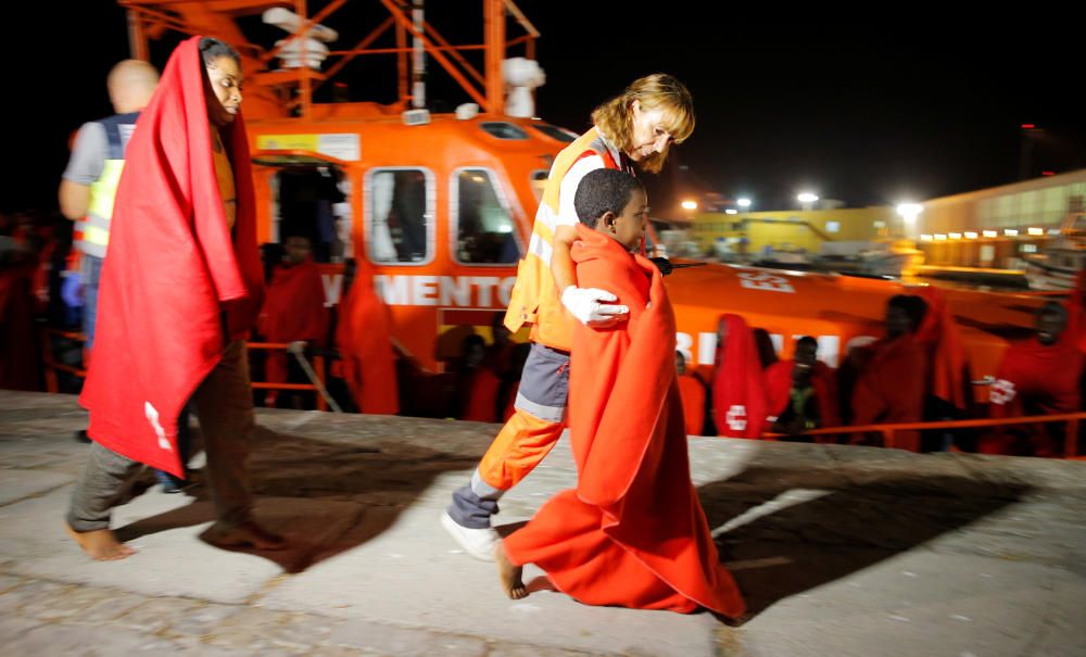 Migrants disembark from a rescue boat at the ...