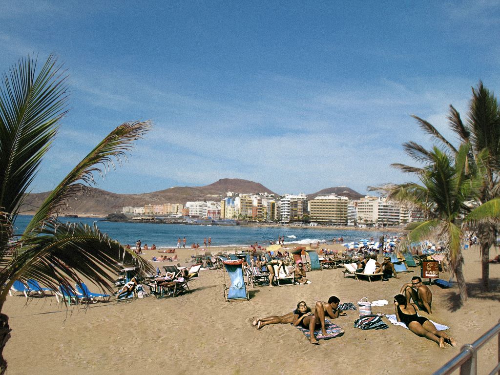 Bañistas disfrutan de un soleado día en la playa de Las Canteras.