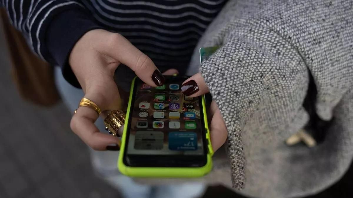 Una persona usa el teléfono móvil .